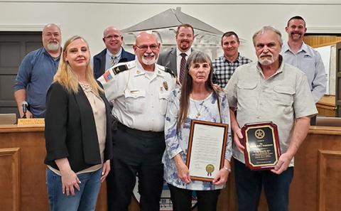 With the city council — Eddie Floyd, Michael Schulman, Mayor Courtney Umbehant, Jeremy Madden, and Andrew Murphy — supporting the honor, Police Chief Bruce Carlisle presents Lt. Scot Stowe’s widow, Crystal, and parents Mary and Gary with recognitions the Lavonia Police Department received because of Stowe’s efforts in capturing a fugitive. (Photo by Sinclair)
