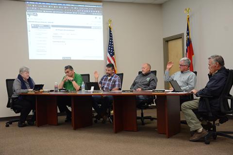 Board members Alan Mitchell, Kent Hall and Gary Minyard vote in favor of entering an agreement 