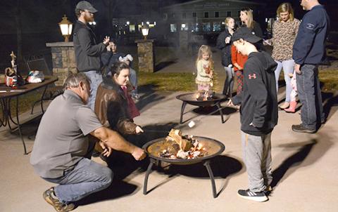 Families roast marshmallows at last year's tree lighting. The event will now be one organized under the city's Downtown Development Authority.
