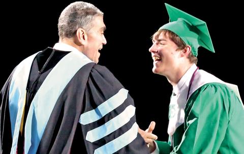 Franklin County School Superintendent Chris Forrer and son Christopher Jr. share a laugh after a big hug just before Chris presents his son his diploma from Franklin County High School during commencement exercises Friday night in Ed Bryant Stadium. (Photo by Scoggins)