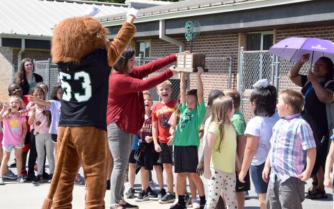 Assistant Principal Jamie Hammock helps Cahlil Holland hold up the Leo Cup during a ceremony Thursday at Lavonia Elementary School. (Photo by Sinclair)