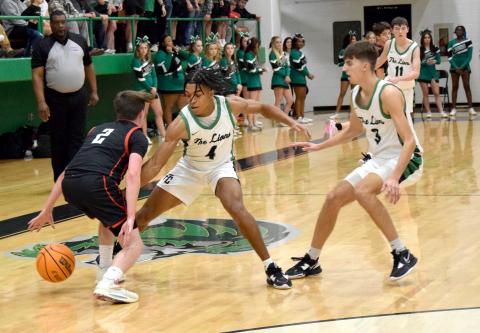 Jeloni Johnson (No. 4) and Cam Maxwell trap a Jackson County ballhandler during action Friday in the Lion’s Den. (Photos by Scoggins)