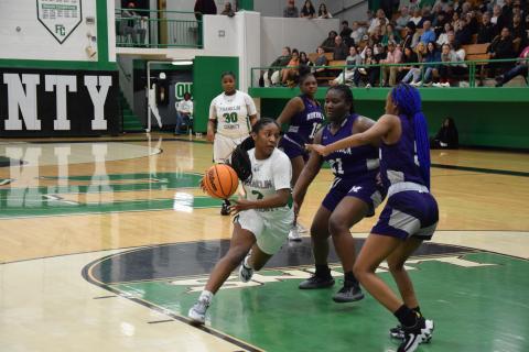 Paris Gaye drives by two Monroe defenders Tuesday in action at the Lion’s Den. Gaye had 23 points to lead the Lady Lions to a win.