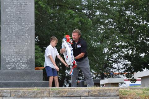 Dusty Morgan and son Shiloh lay a wreath during Memorial Day ceremonies Monday in Carnesville