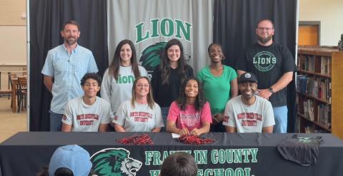 Lexi Knox (seated center) was joined for a celebration of the signing of a track scholarship with North Greenville University by (front, from left) brother Jeromyah Knox, mom Heather Knox, dad Shon Knox, (back) and coaches Aaron Campbell, Megan Jackson, Allie Shubert, Ann Bowman and Josh Bentley.