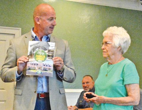 Franklin Springs Mayor Lee Moore presents Emily Phillips with the first commemorative coin and updated history book at Monday’s Franklin Springs City Council Meeting, which was called to commmerate the city’s 100th anniversary. Phillips was recognized as the oldest citizen in the city. (Photo by Eavenson)