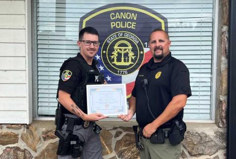 Canon Police Chief Brad Cook (right) presents Officer Austen Carey with a commendation for helping save a life after a recent accident.