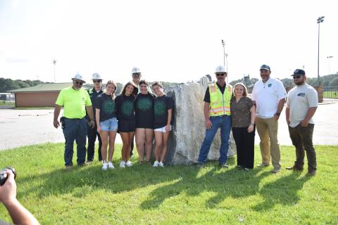 Pictured during delivery of a new boulder for the Franklin County High School campus are (from left) Georgia Stone Products (GSP) Carnesville Foreman Stoney Ervin; Bradlee Edins of GSP; FCHS Student Council members Emily Minish, Abigail Fowler, Peyton Dailey and Brooke Davitt; GSP District Manager Bill Wilson and wife Rebecca; Franklin County Athletic Director Jason Swiney; and Dawson Whaley of Whaley’s Hauling LLC. 