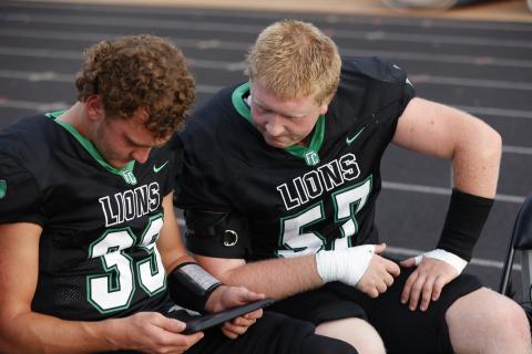 Keyes Harbin (No. 33) looks at a replay with Elijah London (No. 57). (Photo courtesy of Rachel Howington Photography)
