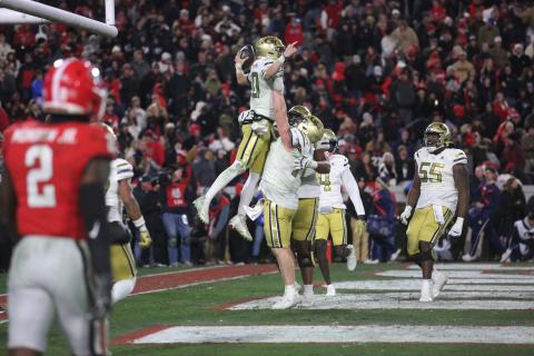 Keylan Rutledge lifts up Georgia Tech teammate and quarterback Haynes King after a touchdown against Georgia in Sanford Stadium. (Photo by Rose Scoggins)