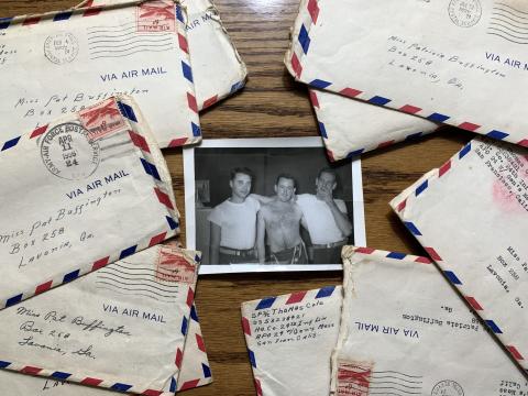 A photo of Tommy Cole with his friends Bill Austin and Ron Burdette lies on a table with letters he wrote to his future wife Trish while serving in Korea during the Korean War.