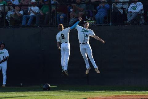 Hudson Huff (No. 9) and Will Dodd (No. 11) celebrate after Huff hit his first career high school home run April 16 against Hebron Christian. Huff, a freshman, hit the home run on Senior Night. (Photo by Scoggins)