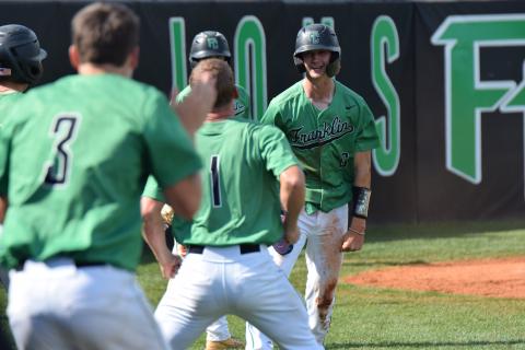 Franklin County teammates stream out of the dugout Saturday to celebrate with Mason Davis (No. 6), who scored one of the Lions’ 10 runs in a victory over East Jackson to clinch a berth in the second round of the state playoffs. (Photos by Scoggins)