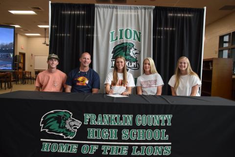 State pole vault champion Macy Moore (seated center) was joined by her family (from left) brother Eli, father Lee, mother Misty and sister Rylee at a scholarship signing ceremony at Franklin County High School. Moore will pole vault for Emmanuel University next year. (Photo by Scoggins)