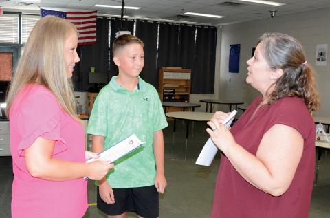 Franklin County Middle School and Franklin County High School held open houses on Tuesday. Information on homeroom assignments, schedules, parking passes, sports teams and clubs were available. FCMS technology and engineering teacher Heather Elo (left photo) explains the Technology Student Association (TSA) to Korbin Reed and his mom, Tiffany Jordan. (Photo by Charlie Eavenson)