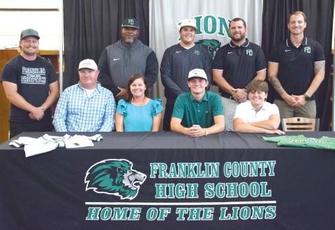 Joining Cade Gibson to celebrate his signing of a baseball scholarship to East Georgia State College are (front, from left) dad Brad Gibson, mother Rebekah Gibson, Cade, brother Nolan Gibson, (back) coaches Ty Tipton, Demond Rivers, Duncan Beasley, Head Coach Ryan Phillips and Drew Phillip. (Photo by Shane Scoggins)