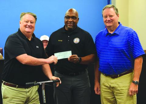 Tracy Dilworth (left) and Stan Dilworth (right) present a $100,000 check to Royston Mayor Keith Turman to go toward building a new water line on Cook Street. (Photo by Shane Scoggins)