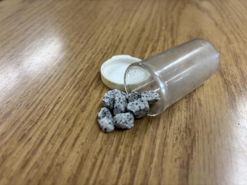 A small pill bottle containing eight pieces of gravel serve as a reminder that in local journalism, you will never see it all.