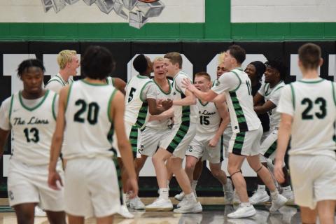 Teammates swarm Sam Shaver after the sophomore made a last-second shot to defeat Habersham Central Dec. 13 in the Lions’ Den. (Photo by Shane Scoggins)