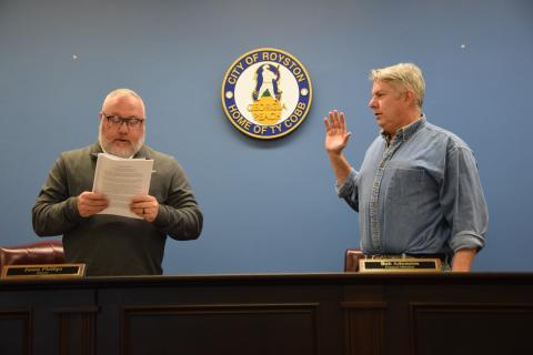 Royston Mayor Jason Phillips (left), presiding over his first meeting as mayor, swore in new Council Member Bob Adamson (right) as well as re-elected members Matt Fields and David Pressley (not pictured) during the Royston City Council’s meeting Tuesday at Royston City Hall. (Photo by Shane Scoggins)