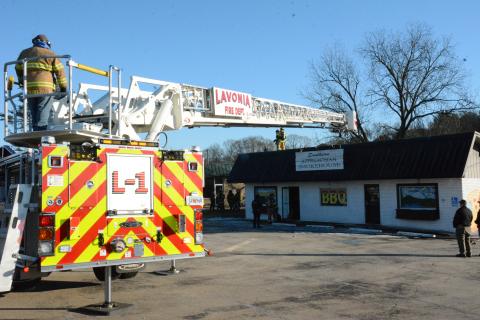 A ladder truck from the Lavonia Fire Department stretchs across to deposit firefighters on the roof of the Southern Applachian Smokehouse restaurant during a fire Tuesday. (Photos by Charlie Eavenson)