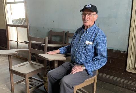 Retired pastor, and former Plainview School student, Isaac McDuffie takes a seat where he attended first grade in 1941. The 90-year-old said he had lots of fond memories from Plainview where he completed all seven grades. He stopped by during a planned work day Saturday. (Photo by Charlie Eavenson)
