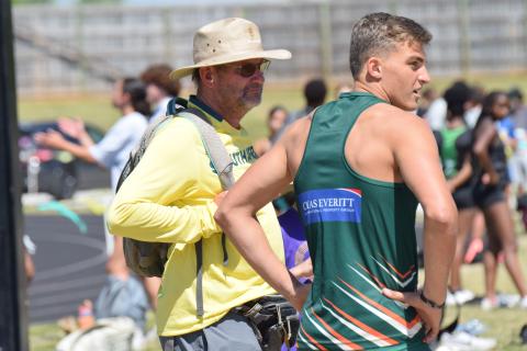 Coach Blackie Swart (left) and Dian Huisemen of Rustenburg High School in South Africa stand at the triple jump pit during Saturday’s John Scott Hartness Invitational track and field meet at Franklin County High School. (Photo by Shane Scoggins)