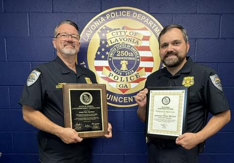 Lavonia Police Chief Shane Edmisten (left) and State Certification Manager Lt. Wayne Mitchum (right) show off the department’s recertification plaques the department earned.