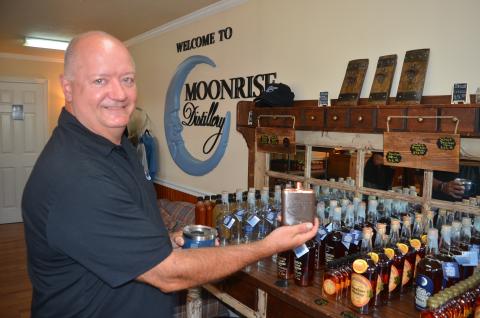 Moonrise DIstillery owner Doug Nassaur shows some of the many bourbon-related products offered for sale at the Clayton distillery.