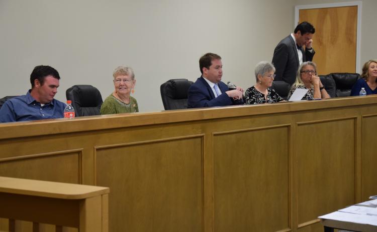 Franklin County Board of Elections and Registration members (from left) Roman Strickland, Alice Black, Chairman Doug Kidd, Sherry MacDonald and Angela Whidby (with County Attorney Bubba Samuels and Elections Superintendent Gina Kesler) prepare to listen to tesimony following a break in a hearing Wednesday on a challenge to the residency of Lee and Sheena Strickland.