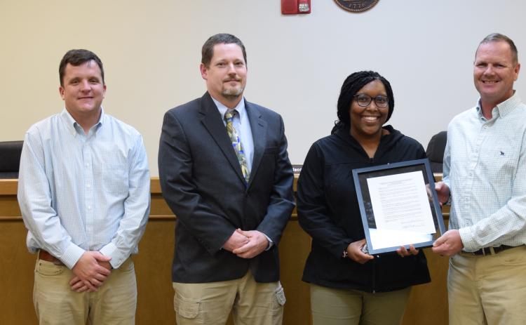 Raeshonda Thornton receives a framed copy of a resolution naming the gym at Rocky Ford Park in honor of her father, Michael Mayfield Sr. Franklin County Commissioners (from left) Robert Franklin, Kyle Foster, Chairman Jason Macomson, Eddie Wester and Ryan Swails approved the resolution Tuesday. (Photo by Scoggins)