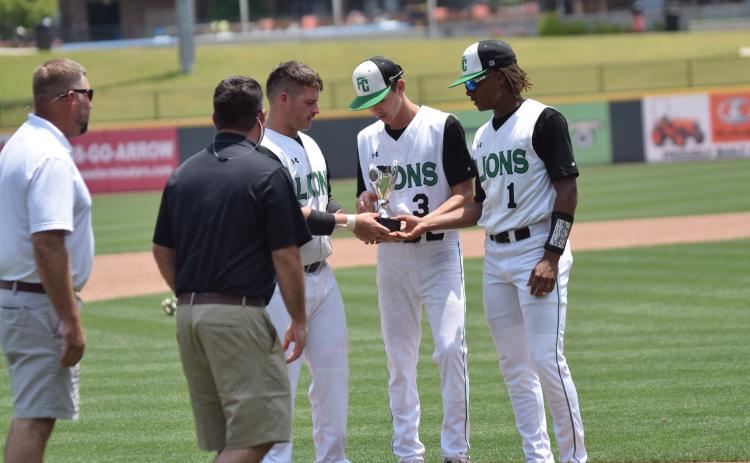 Seniors Evan Herring, J.D. Ginn and C.J. Blackwell accept the state runner-up trophy Monday at CoolRay Field in Lawrenceville.