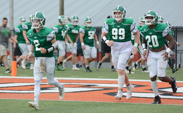 Chris Goode (No. 2), Keylan “Red” Rutledge (No. 99) and Jontavion “Jo Jo” Hughes (No. 20) lead the Franklin County Lions onto the field Saturday at Herndon Stadium for action in the Lake Hartwell Gridiron Classic football jamboree. (Photo by Scoggins)