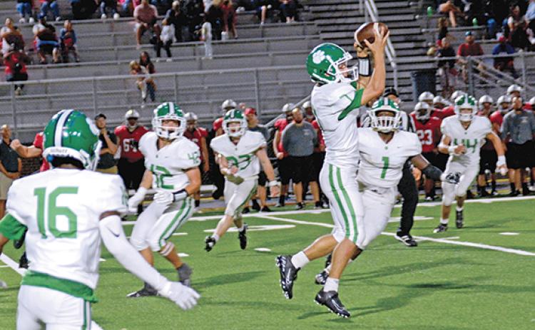Lion Dee Oliver jumps up to snag an interception in the third quarter of Friday's game at Jackson County. Oliver returned the interception for his second touchdown of the game. His first came on the second-half kickoff return. (Photo by Scoggins)