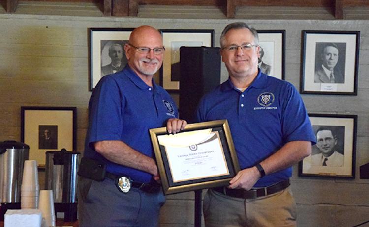Lavonia Police Chief Bruce Carlisle receives the Meritorious Gold Award from Butch Ayers, the executive director of the Georgia Association of Chiefs of Police. (Photo by Sinclair)