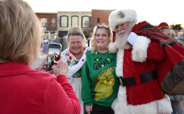 Gloria Allred takes a photo of Heather Bridges with Mrs. Claus and Santa Claus after his arrival in Lavonia for the city's tree lighting event. (Photo by Sinclair)