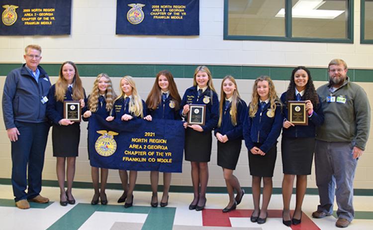 Kent Benson and Brian Elrick present Franklin County Middle School FFA officers Ava Gray, Rylie Sanders, Meghan Langley, Darby Roach, Camryn Childs, Scarlett Killen, Callie Walker, Ella Maisonneuve with the chapter’s 2021 Area 2 awards. (Photo by Sinclair)