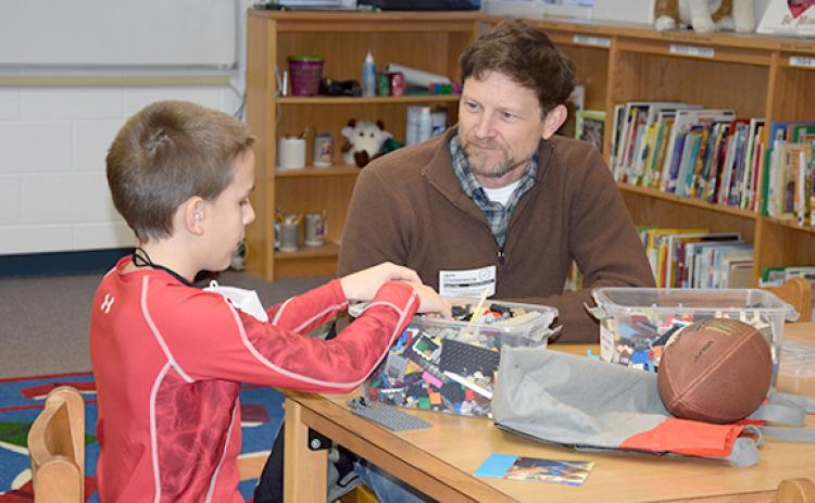 Mentor Jeff Stephenson talks with Shane as they build with Lego bricks together. The Franklin County Mentor Volunteer Program is in need of more volunteers like Stephenson. (Photo by Sinclair)