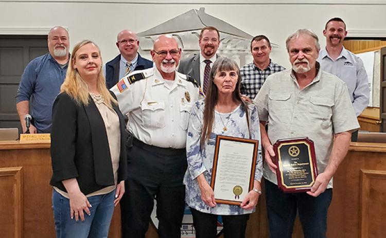 With the city council — Eddie Floyd, Michael Schulman, Mayor Courtney Umbehant, Jeremy Madden, and Andrew Murphy — supporting the honor, Police Chief Bruce Carlisle presents Lt. Scot Stowe’s widow, Crystal, and parents Mary and Gary with recognitions the Lavonia Police Department received because of Stowe’s efforts in capturing a fugitive. (Photo by Sinclair)