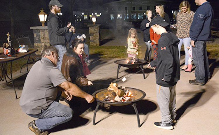 Families roast marshmallows at last year's tree lighting. The event will now be one organized under the city's Downtown Development Authority.