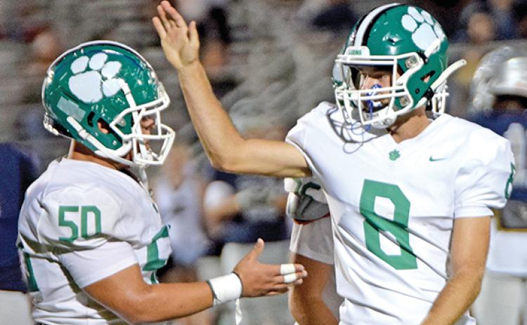 Tarryn Tate (left) and Jonathan Duncan celebrate Friday after Duncan’s 37-yard field goal against East Jackson.