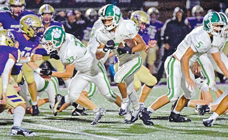 Freshman Nava Ware runs through a hole in the Lumpkin County line opened by Colbey Freeman (No. 33) and Tyler Pursley (No. 5) in action Friday in Dahlonega. (Photo by Scoggins)