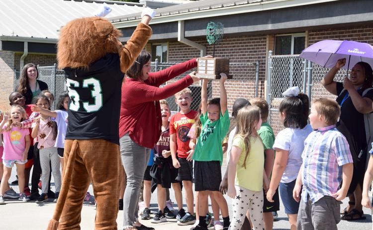 Assistant Principal Jamie Hammock helps Cahlil Holland hold up the Leo Cup during a ceremony Thursday at Lavonia Elementary School. (Photo by Sinclair)