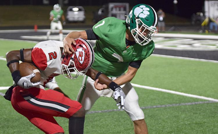 Lion Dee Oliver (No. 7) wrestles a Stephens County receiver to the ground. (Photo by Scoggins)