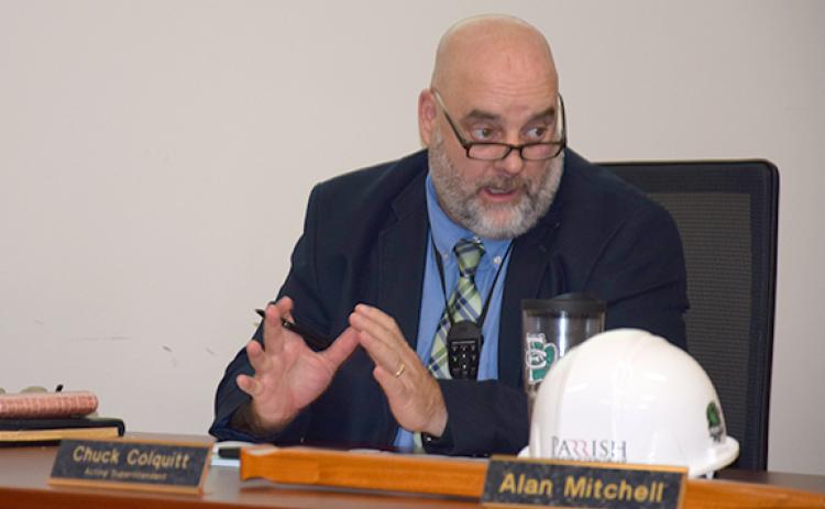 Acting Superintendent Chuck Colquitt wears a microphone around his neck to demonstrate a new audio system that has been installed in classrooms. Together with new cameras, the system allows teachers to video lessons for students unable to attend, and the microphones amplify voices so students can hear better. (Photo by Sinclair)
