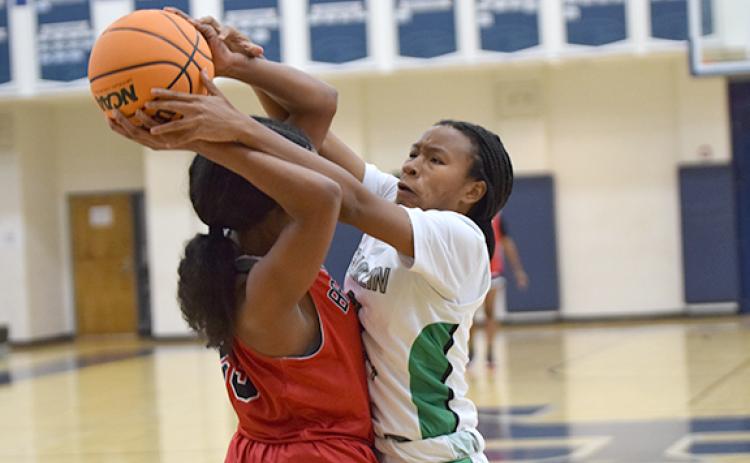 Ta’Kiaha Winkfield ties up a Flowery Branch ballhandler in tournament action Monday in Commerce. (Photo by Scoggins)