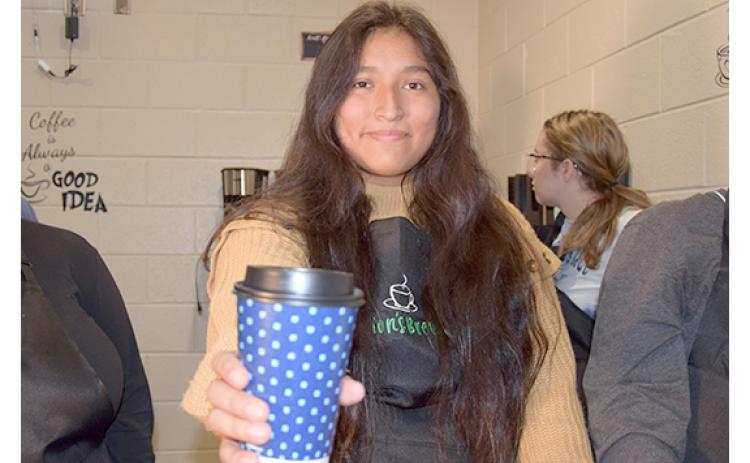 Jennifer Sigala hands out a cup of coffee in the Lion's Brew, a new coffee shop that will open Nov. 16 at Franklin County High School. (Photo by Sinclair)