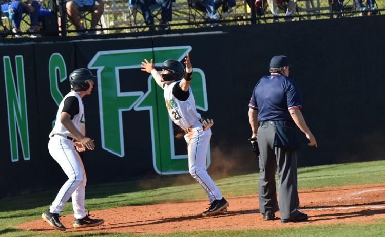 Easton Gailey and Keilin Sanders celebrate after Sanders scored a run in recent region action at FCHS.