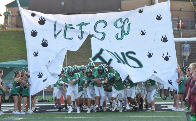 CARNESVILLE – The Franklin County Lions busts through a banner Friday night before its preseason scrimmage against Madison County at Jeff Davis Field at Ed Bryant Stadium. The season opener for the Lions will be this Friday at FCHS against  the Chestatee War Eagles. Kickoff will be at 7:30 p.m. For a complete preview of the Lions football team, band and cheerleaders, see this year’s issue of Franklin Friday Nights inside this week. (Photo by Scoggins)