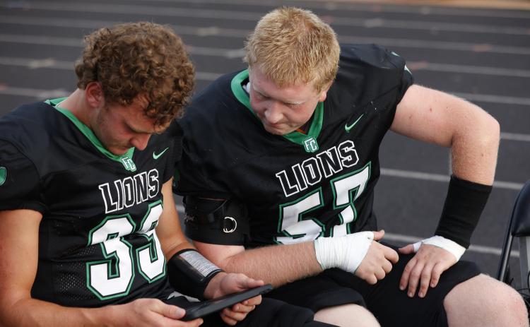 Keyes Harbin (No. 33) looks at a replay with Elijah London (No. 57). (Photo courtesy of Rachel Howington Photography)